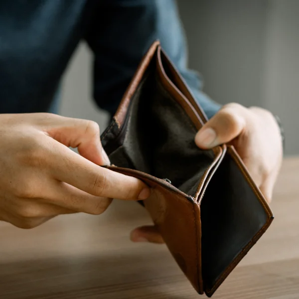 A man holding an empty wallet, symbolizing financial struggles