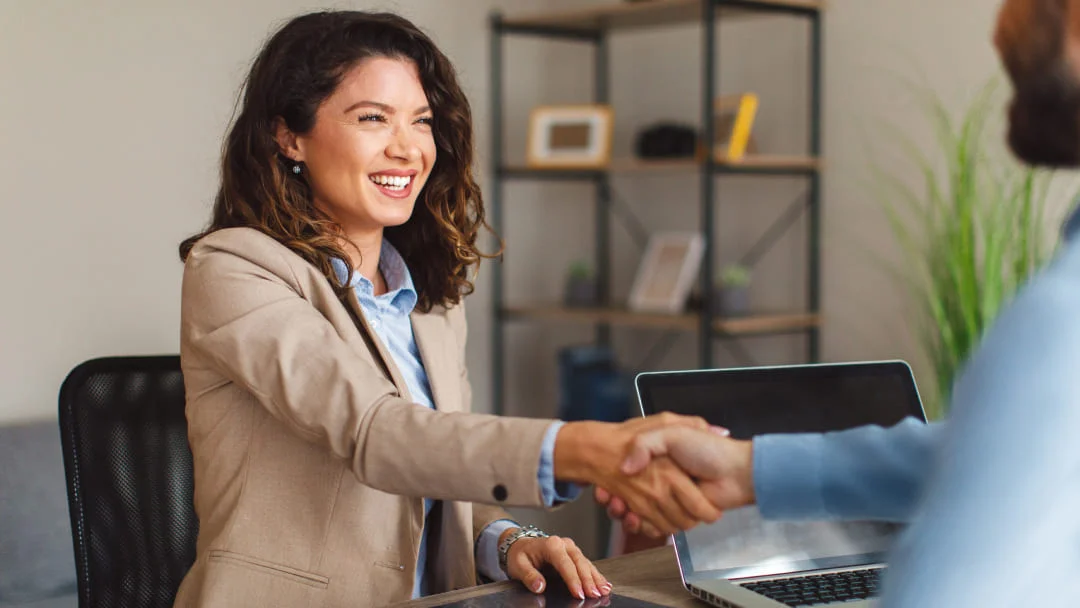 Une femme serre la main d'un homme à un bureau